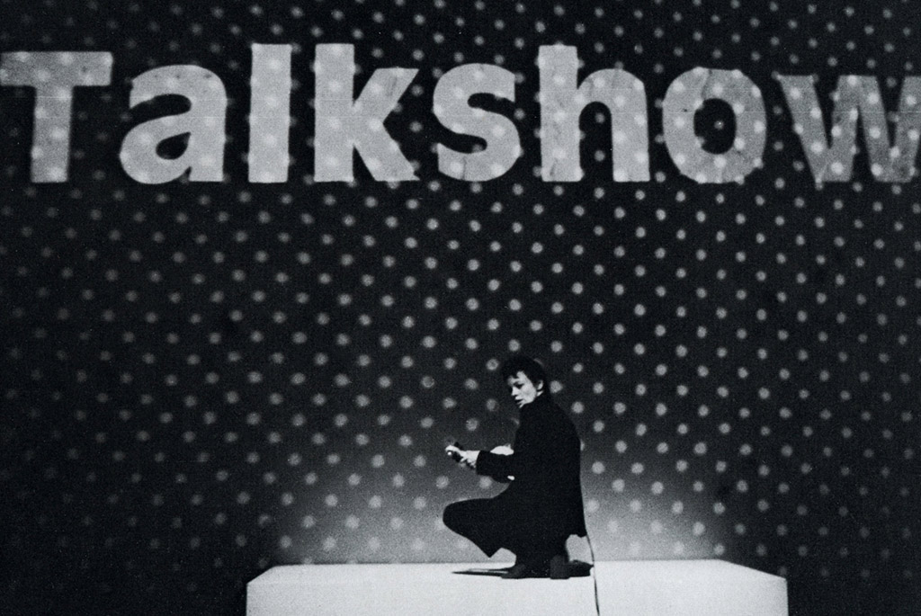 laurie anderson on stage in front of Talk Show banner